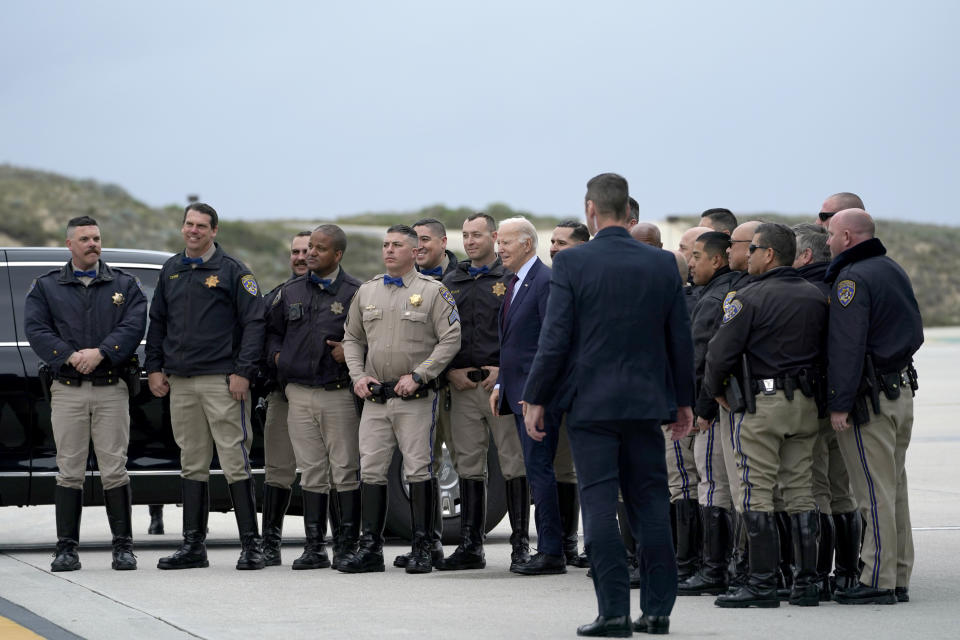 President Joe Biden, center, takes a photo with members of law enforcement before boarding Air Force One at Los Angeles International Airport in Los Angeles, Sunday, Feb. 4, 2024, en route to Las Vegas to participate in campaign events. (AP Photo/Stephanie Scarbrough)