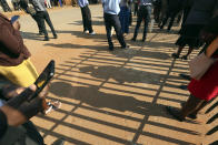 People wait to enter the magistrates courts in Harare, Tuesday, Sept. 22, 2020. As Zimbabwe's coronavirus infections decline, strict lockdowns designed to curb the disease are being replaced by a return to relatively normal life. The threat has eased so much that many people see no need to be cautious, which has invited complacency. (AP Photo/Tsvangirayi Mukwazhi)