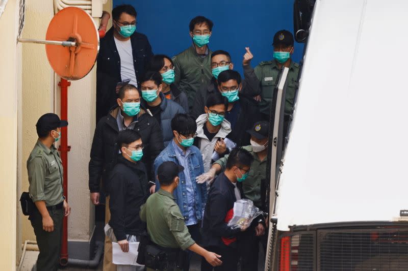 Pro-democracy activists including Alvin Yeung, Eddie Chu and Jeremy Tam walk to a prison van to head to court, over national security law charges, in Hong Kong