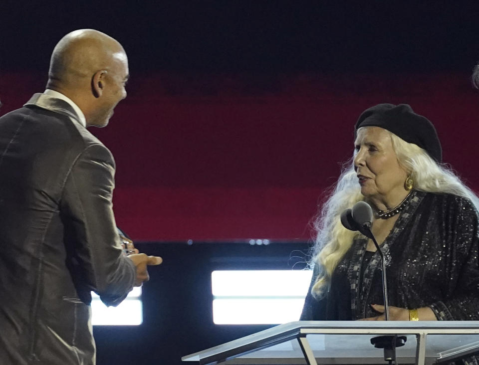 Harvey Mason Jr., CEO of the Recording Academy and MusiCares, left, presents the Person of the Year award to Joni Mitchell at the 31st annual MusiCares benefit gala honoring on Friday, April 1, 2022, at the MGM Grand Conference Center in Las Vegas. (AP Photo/Chris Pizzello)