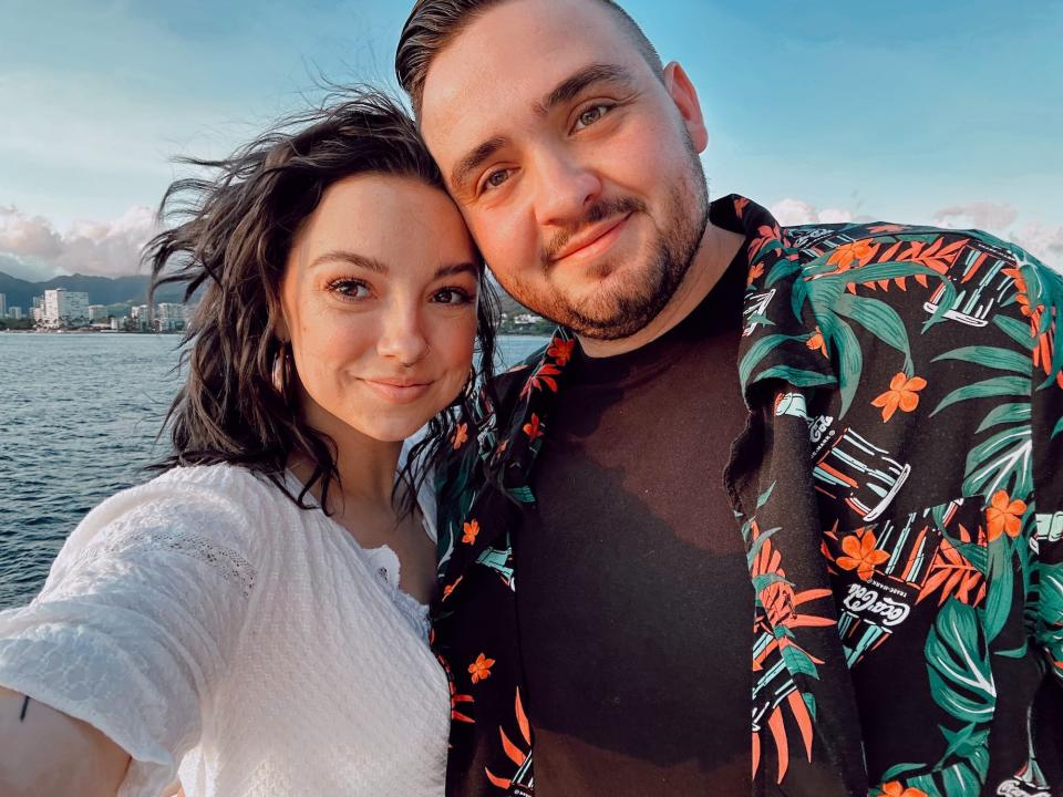 A selfie of a man and a woman in front of water.