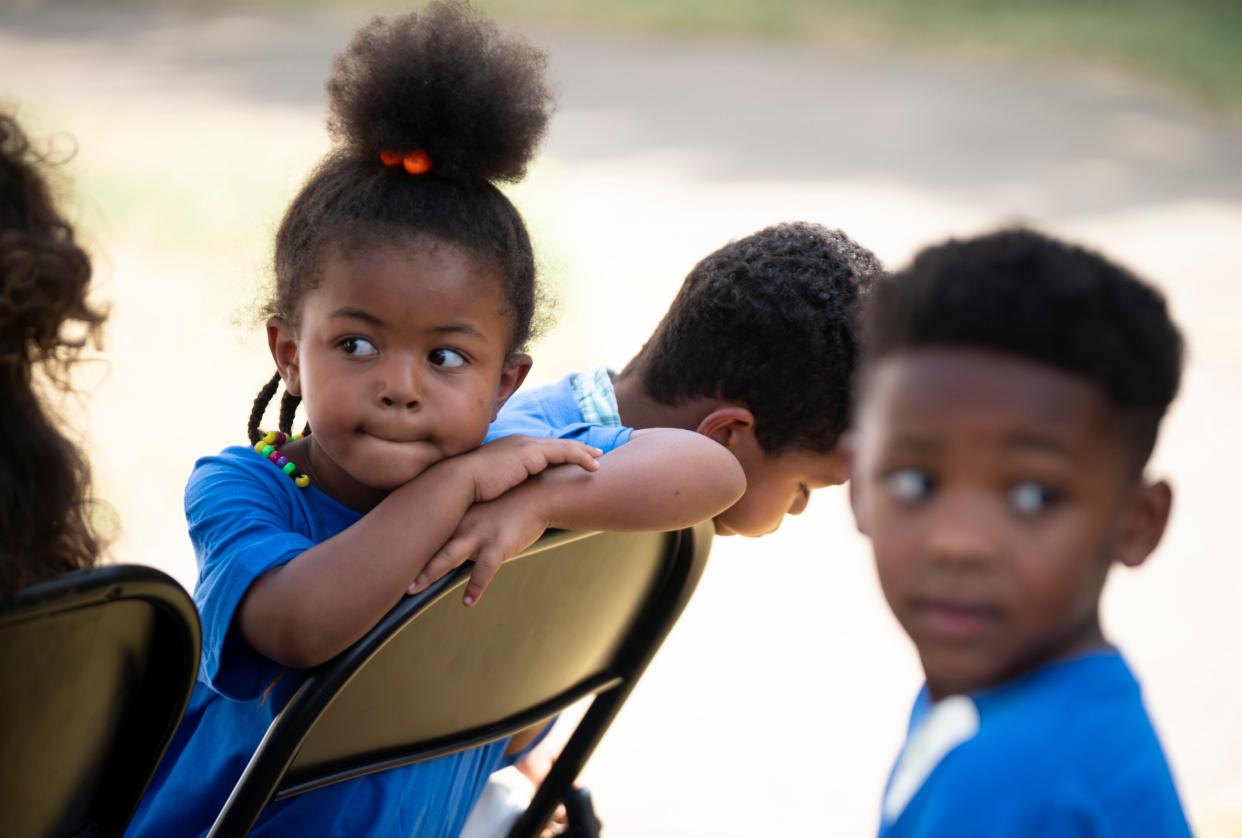 Kyzala Bauman, 4, left, Selmon Ali, 4, center, and Khalyn Salters, 3, sit through the official speeches during the groundbreaking ceremony for the Storybook Trail at Napier Elementary School in Nashville, Tenn., Thursday, Aug. 29, 2024.