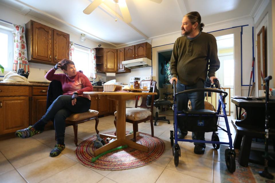 From left, Kate Brighton and Benjamin Brighton speak in his Somersworth home.