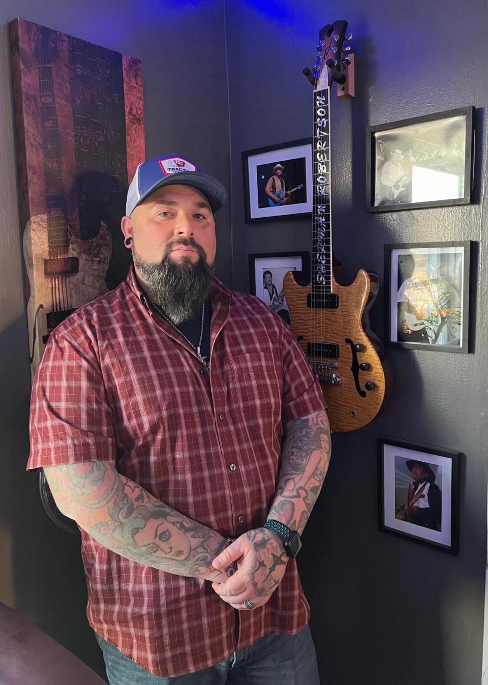 Aaron Hymes is shown with a guitar once played by his late stepfather Sherman Robertson, an accomplished guitarist and singer. Hymes is a Stark County-based musician who is recording Christian-inspired country music in Nashville.