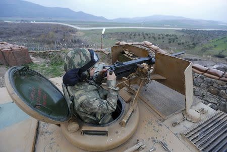 A Turkish soldier on an armoured military vehicle surveys the border line between Turkey and Syria, near the southeastern city of Kilis, Turkey, March 2, 2017. REUTERS/Murad Sezer