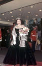 Queen Elizabeth II attends the premiere of the 1957 film Gigi in high style, wearing a black velvet ball gown with a fur stole.