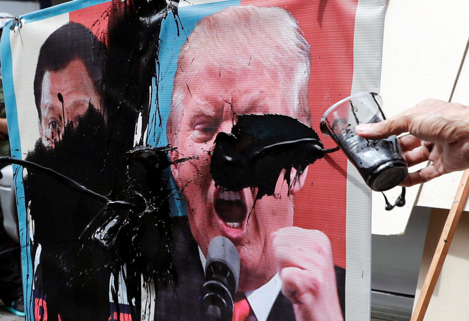 <p>Protesters smear images of President Donald Trump and Philippine President Rodrigo Duterte with paint during a rally against the U.S. President’s visit near the U.S. Embassy, in Manila, Philippines Nov. 10, 2017. (Photo: Erik De Castro/Reuters) </p>