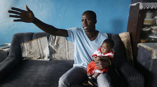 Donnell Tholley, 25, holds his adopted son Donnell Junior at their apartment in Freetown, Sierra Leone. Tholley adopted the boy following the death of the mother Fatu Turay last year from the Ebola virus at the hospital on the outskirts of Freetown, Sierra Leone.