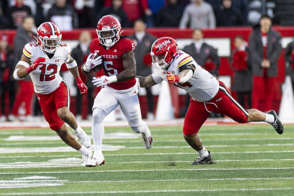 Maryland defensive back Dante Trader Jr. (12) and linebacker Caleb Wheatland (44) try to bring down Rutgers running back Kyle Monangai (5) in the first half of an NCAA college football game, Saturday, Nov. 25, 2023, in Piscataway, N.J. (AP Photo/Corey Sipkin)