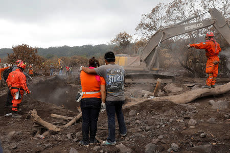 Eva Ascon, is embraced by a family member as rescue workers search for her rest of her family at the affected by the Fuego volcano at San Miguel Los Lotes in Escuintla, Guatemala June 15, 2018. REUTERS/Carlos Jasso