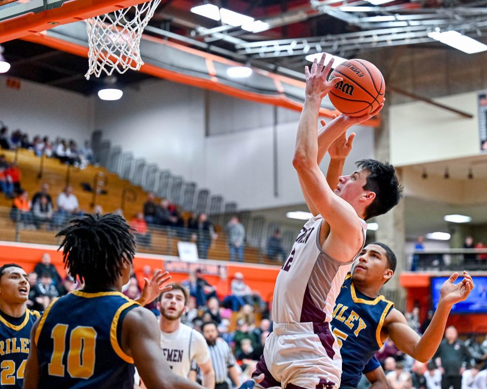 Mishawaka's Cooper Pritchett (12) goes up for a shot as Riley's Caleb Francis (15) defends in the first half of their sectional game Saturday, March 4, 2023, at LaPorte High School.