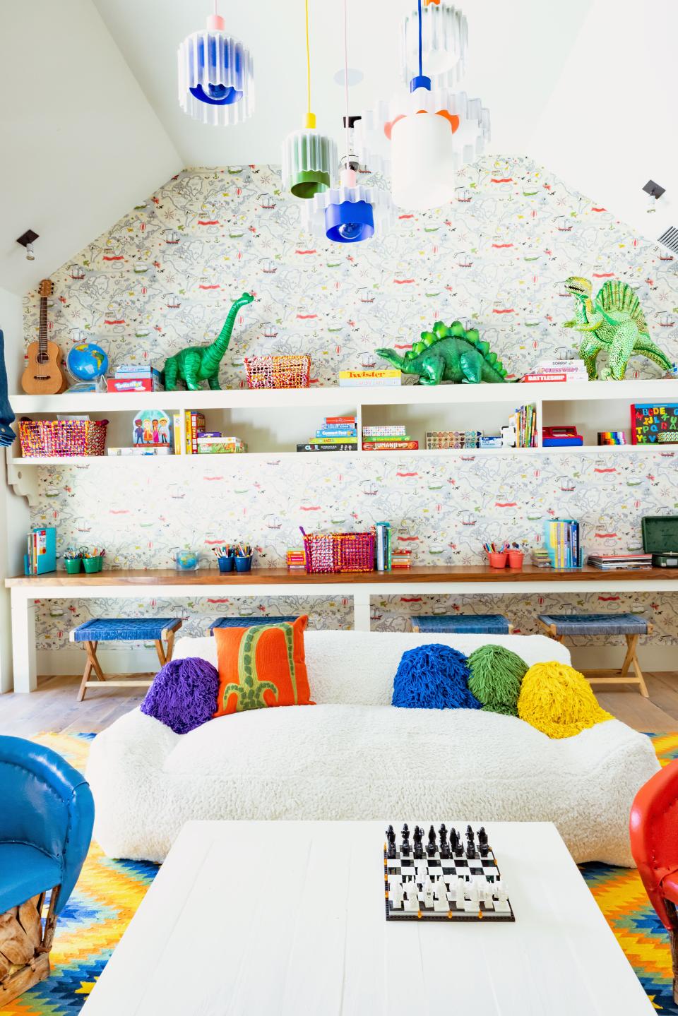 Five recycled-plastic pendants by Warren & Laetitia hang in the kids’ playroom above an RH Kids sofa with crochet pillows from Coming Soon NY. The wallpaper is by Walnut. The four indigo benches are from Lost & Found L.A.