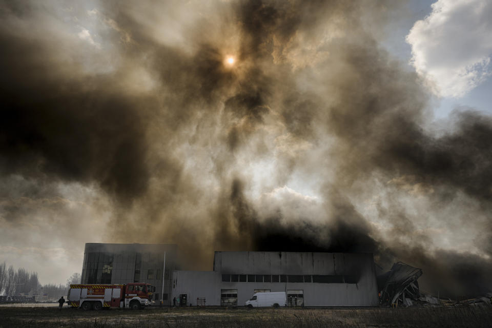 Heavy smoke billows from a destroyed warehouse after a Russian bombardment on the outskirts of Kyiv, Ukraine, Thursday, March 24, 2022. Ukraine President Volodymr Zelenskyy called on people worldwide to gather in public Thursday to show support for his embattled country as he prepared to address U.S. President Joe Biden and other NATO leaders gathered in Brussels on the one-month anniversary of the Russian invasion. (AP Photo/Vadim Ghirda)