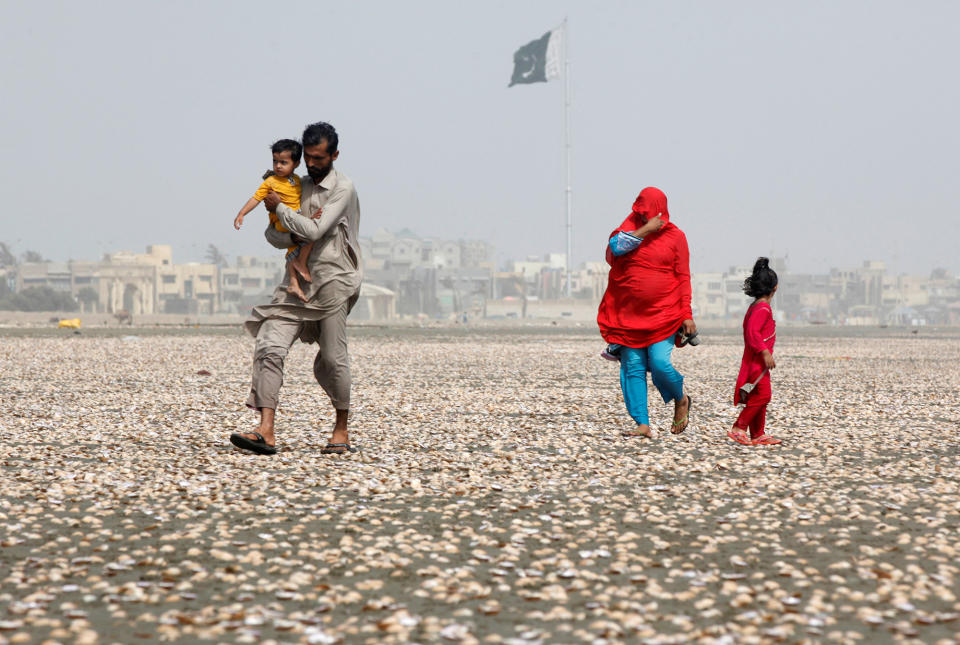 <p>A woman covers her face with scarf to avoid heat while walking with her family along the beach on a hot summer day in Karachi, Pakistan, May 20, 2016. (Akhtar Soomro/REUTERS) </p>