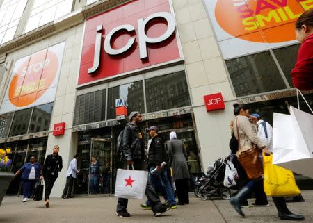 A man with a Macy's bag walks past the J.C. Penney's store in New York, April 11, 2013. REUTERS/Brendan McDermid/File Photo