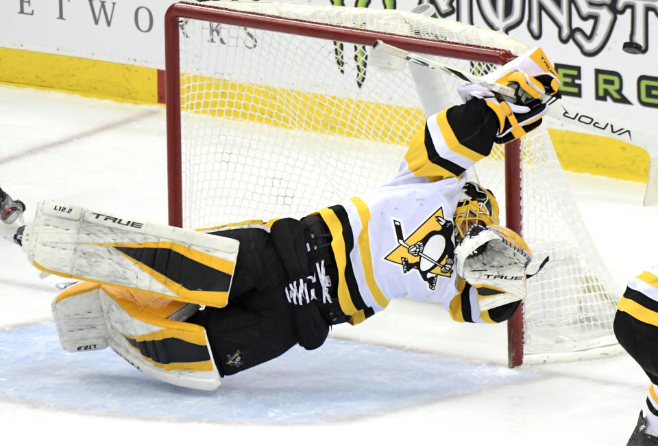 Pittsburgh Penguins goaltender Casey DeSmith deflects the puck during the second period of the team's NHL hockey game against the New Jersey Devils on Friday, April 9, 2021, in Newark, N.J. (AP Photo/Bill Kostroun)