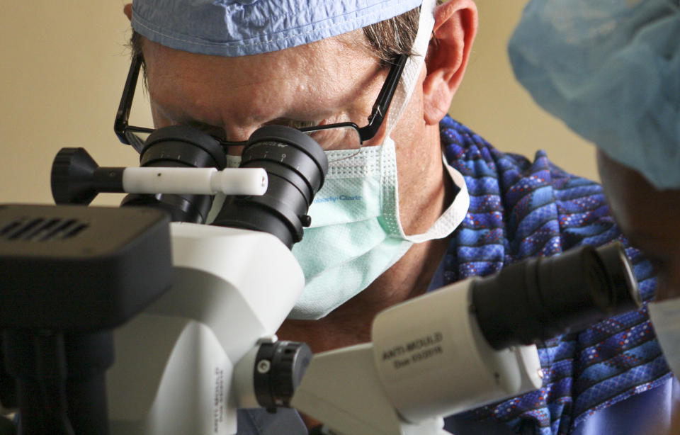 In this photo taken Dec. 15, 2012 and released by the Moran Eye Center, Dr. Alan Crandall, Vice-Chair of the Department of Ophthalmology/Visual Sciences and Co-Director of the International Program at the John A. Moran Eye Center of the University of Utah, teaches a local Dinka clinician, right, the steps involved with cataract surgery in the village of Duk Payuel in Jonglei state, South Sudan. South Sudan's government faces monumental challenges: To bring warring factions, often from rival ethnic groups, back toward peace after violence broke out across the country on Dec. 15, but a group of American doctors has a unique approach to help heal age-old rifts between the ethnic groups, eye surgery, although it has been put on hold because of the fighting. (AP Photo/Moran Eye Center, Patrick Reddish)