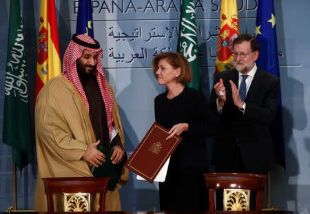 Saudi Arabia's Crown Prince Mohammed bin Salman stands next to Spain's Defence Minister Maria Dolores de Cospedal after signing a framework deal as Spain's Prime Minister Mariano Rajoy applauds at the Moncloa Palace in Madrid, Spain, April 12, 2018. REUTERS/Juan Medina