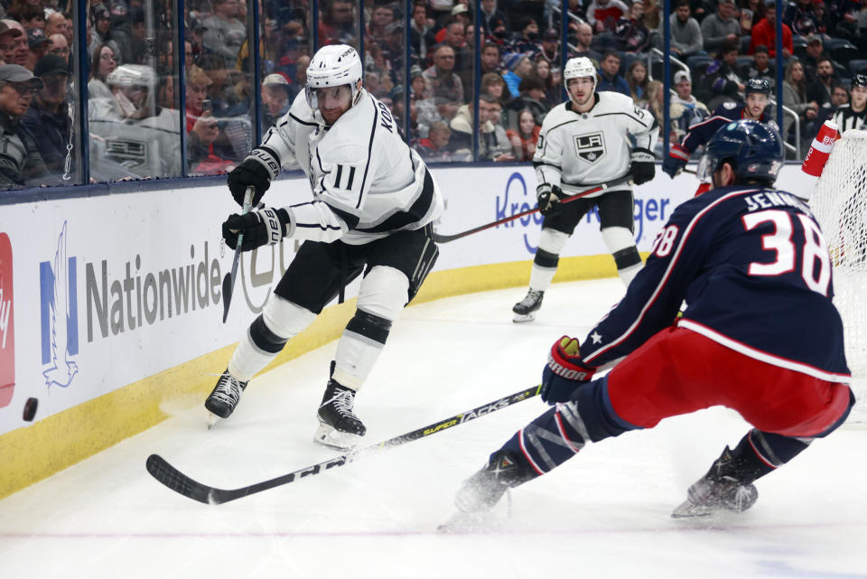 Los Angeles Kings forward Anze Kopitar, left, passes the puck in front of Columbus Blue Jackets forward Boone Jenner during the second period of an NHL hockey game in Columbus, Ohio, Sunday, Dec. 11, 2022. (AP Photo/Paul Vernon)