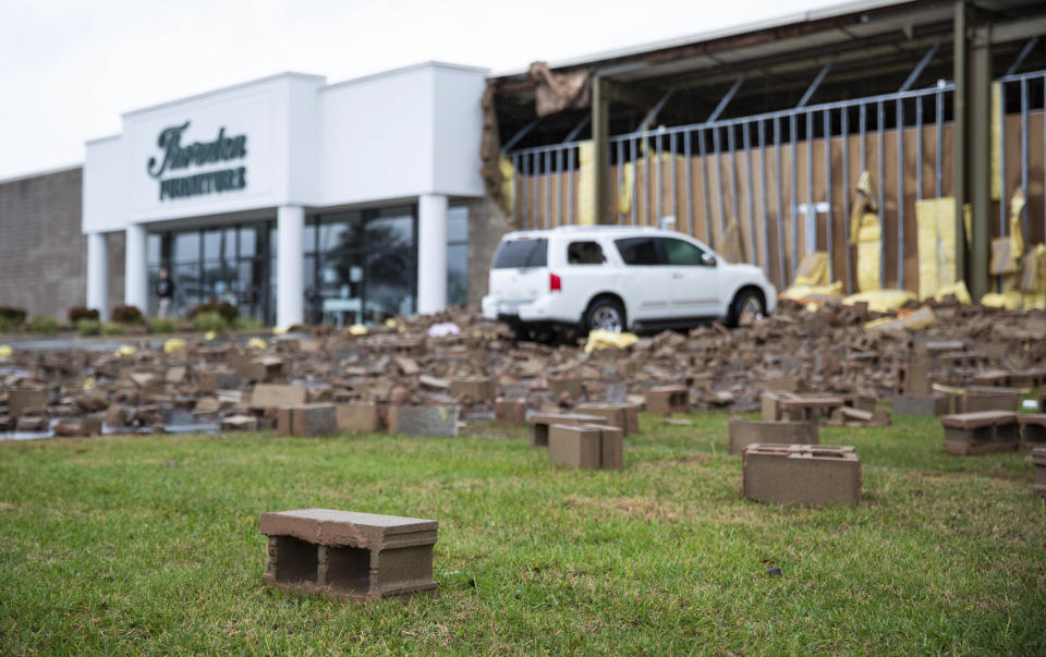 Cinder blocks and building debris litter the front parking lot of Thornton Furniture on Cave Mill Road in Bowling Green, Ky., after another tornado warning was issued late Saturday morning, Jan. 1, 2022, for Warren and surrounding counties, following the devastating tornadoes that tore through town on Dec. 11, 2021. Though the damage from Saturday's storm proved less catastrophic than the system that passed through in December, heavy rain and strong winds battered the area, causing damage along Cave Mill Road and the surrounding area. (Grace Ramey/Daily News via AP)