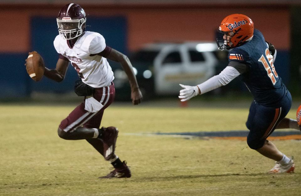 Pensacola High quarterback Nino Freeman (No. 8) runs for the safety of the near sideline as Escambia High's Eric Burch (No. 10) gives chase during Thursday night's rivalry game.