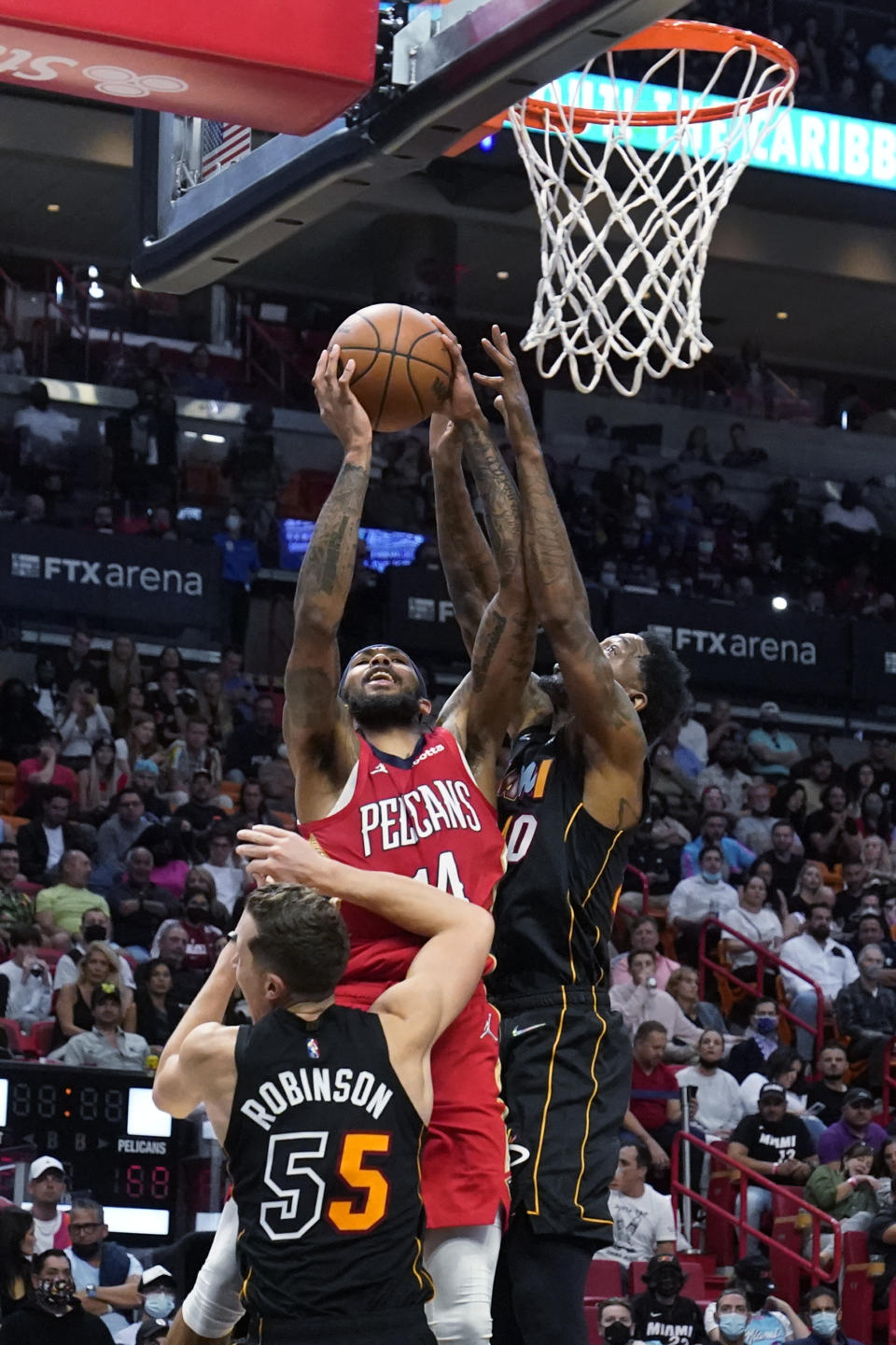 New Orleans Pelicans forward Brandon Ingram goes up for a shot against Miami Heat forward Duncan Robinson (55) and forward Udonis Haslem, right, during the second half of an NBA basketball game, Wednesday, Nov. 17, 2021, in Miami. (AP Photo/Wilfredo Lee)