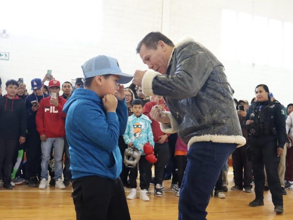 Legendary Mexican boxer Julio César Chávez teaches a Juárez boy some basic boxing techniques on Friday, Jan. 19, 2024, during a motivational speech to children at the Raul Palma Cano Municipal Gymnasium in Juárez, Mexico.