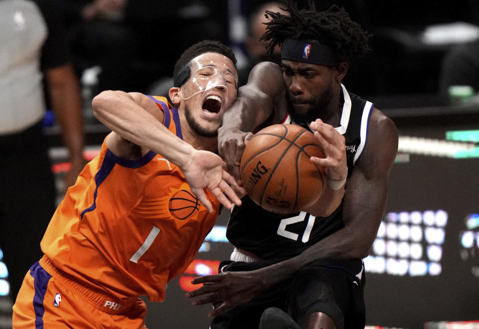 Patrick Beverley #21 of the LA Clippers blocks the shot by Devin Booker #1 of the Phoenix Suns in the first half of game three of a Western Conference finals NBA playoff basketball game at the Staples Center in Los Angeles on Thursday, June 24, 2021. (Keith Birmingham/The Orange County Register via AP)