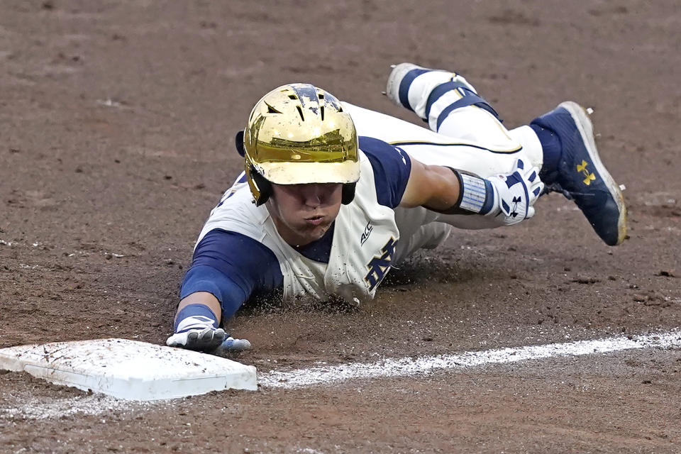 Notre Dame's Brooks Coetzee (42) reaches back to tag first base after the ball gets away from Mississippi State's first baseman during an NCAA college baseball super regional game, Sunday, June 13, 2021, in Starkville, Miss. (AP Photo/Rogelio V. Solis)