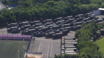 In this image made from video, armed police vehicles are parked outside Shenzhen Bay Stadium in Shenzhen, near Hong Kong, Friday, Aug. 16, 2019.(AP Photo/Dake Kang)