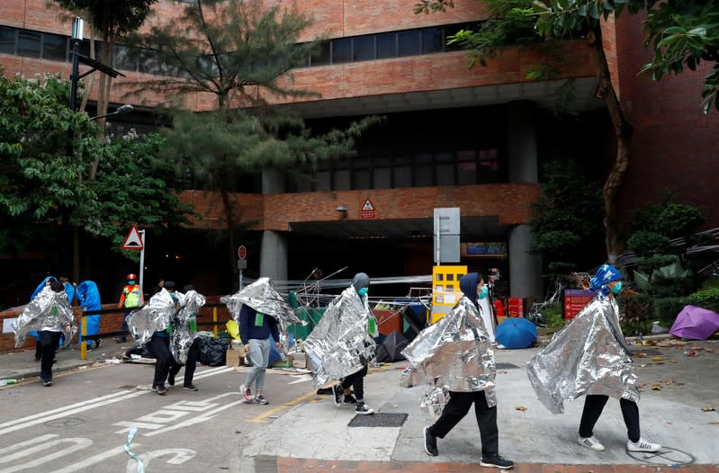 Manifestantes abandonan el campus de la Universidad Politécnica de Hong Kong para rendirse a la policía, en Hong Kong, China, el 19 de noviembre de 2019