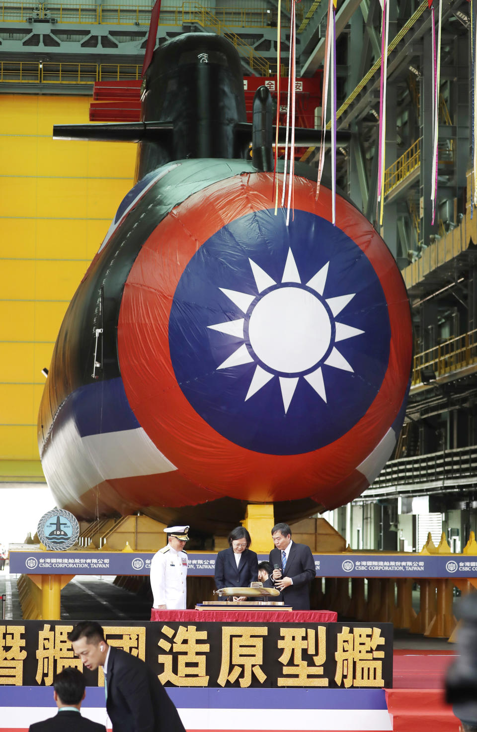 Taiwan's President Tsai Ing-wen, center, standing in front of a covered submarine, attends the launching ceremony of domestically-made submarines at CSBC Corp's shipyards in Kaohsiung, Southern Taiwan, Thursday, Sept. 28, 2023. The submarine, if successful in its tests, will be a major breakthrough for Taiwan in shipbuilding and design. (AP Photo/Chiang Ying-ying)
