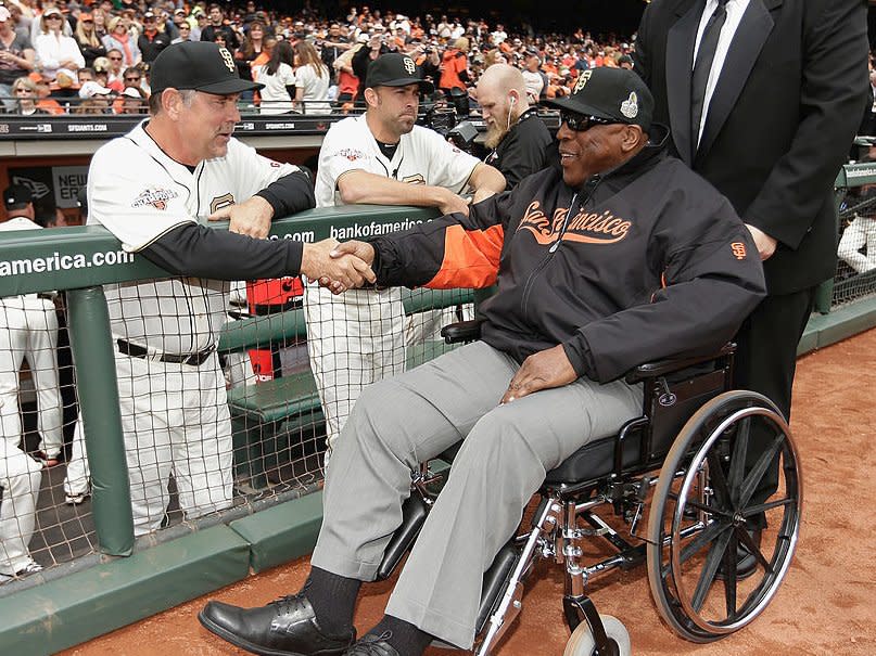 Manager Bruce Bochy (left) of the San Francisco Giants shakes hands with Hall of Famer Willie McCovey