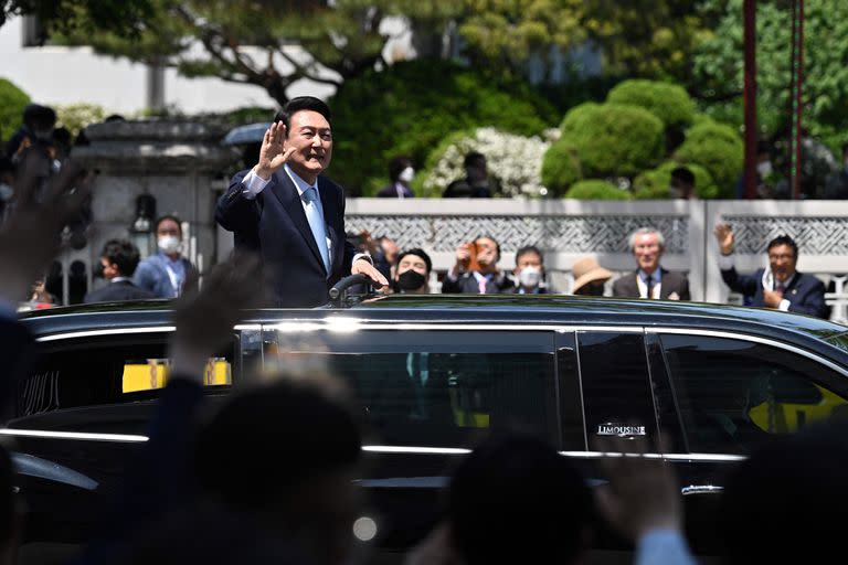 Simpatizantes aplauden mientras el presidente surcoreano Yoon Suk-yeol saluda desde su coche tras la ceremonia de investidura en la Asamblea Nacional de Seúl el 10 de mayo de 2022.