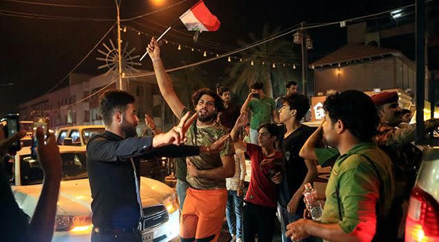 Iraqi citizens of Basra celebrate the news of their country's victory over Islamic State terrorists at Mosul. Photo: AP