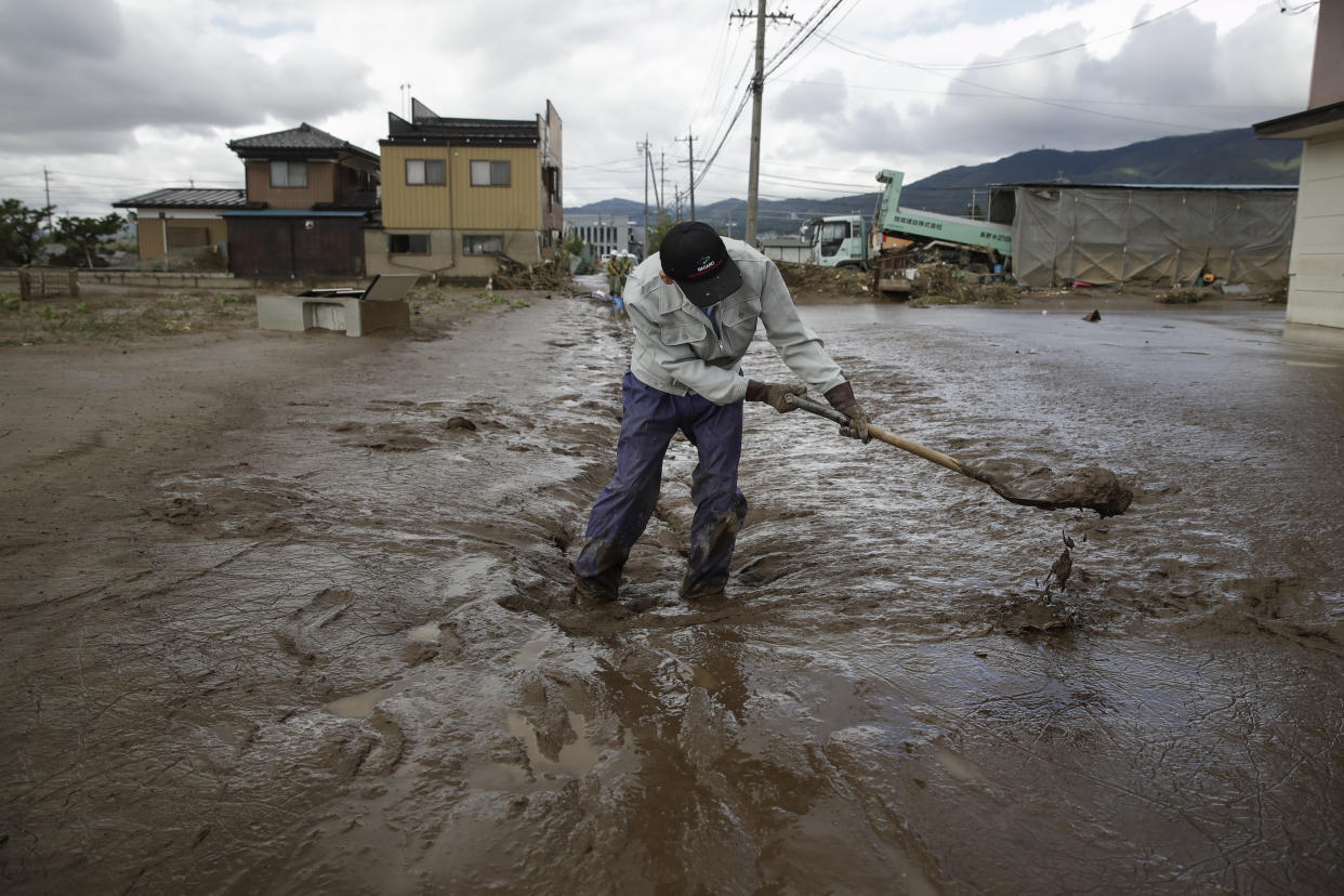 A man uses a shovel to scoop mud in a neighborhood devastated by Typhoon Hagibis, Oct. 15, 2019, in Nagano, Japan. (Photo: Jae C. Hong/AP)