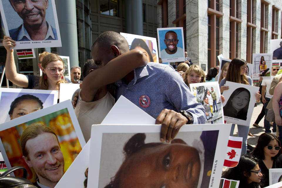 Paul Njoroge of Kenya, holds the picture of his daughter as he gets a hug during a vigil on the six-month anniversary of the crash of a Boeing 737 Max 8, killing 157 people, in Ethiopia on March 10, which has resulted in the grounding hundreds of the planes worldwide, outside of the Department of Transportation, Tuesday, Sept. 10, 2019 in Washington. (AP Photo/Jose Luis Magana)