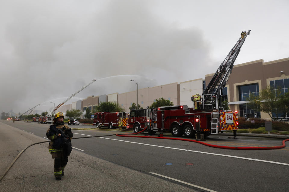 Firefighters battle a warehouse fire Friday, June 5, 2020, in Redlands, Calif. The fire destroyed the commercial building, about 60 miles east of Los Angeles, but there are no reports of injuries. (AP Photo/Jae C. Hong)