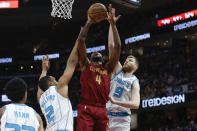 Cleveland Cavaliers forward Evan Mobley (4) shoots against Charlotte Hornets forward Grant Williams (2) and forward Davis Bertans (9) during the first half of an NBA basketball game, Monday, March 25, 2024, in Cleveland. (AP Photo/Ron Schwane)