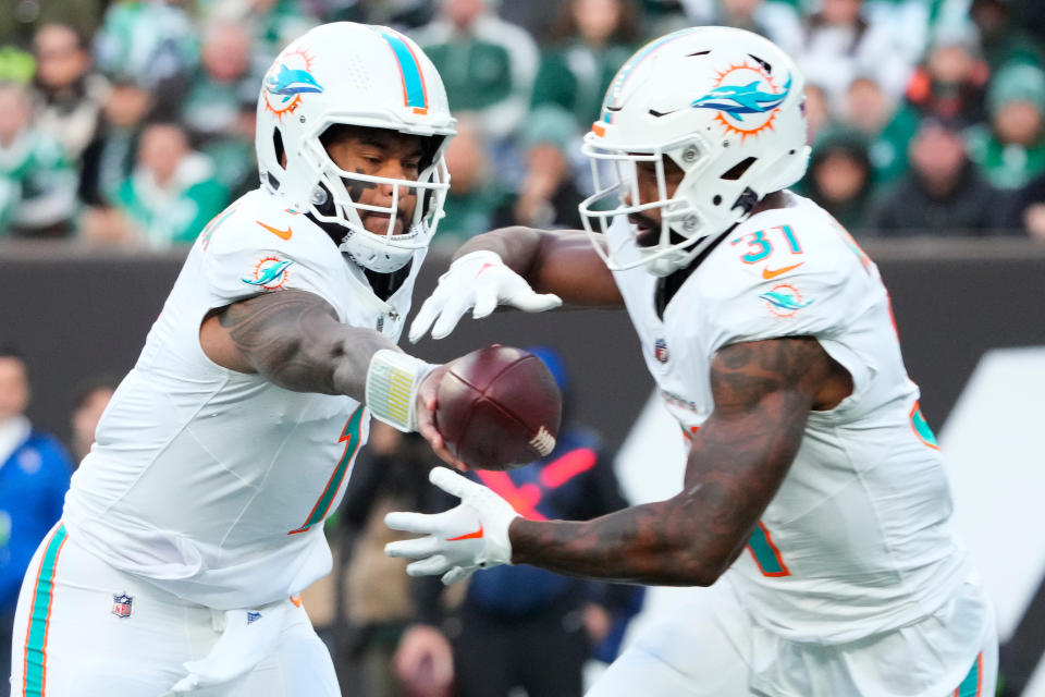 Miami Dolphins quarterback Tua Tagovailoa (1) hands off the ball to Miami Dolphins running back Raheem Mostert (31). Mandatory Credit: Robert Deutsch-USA TODAY Sports