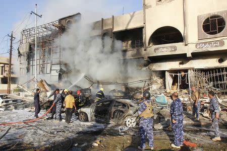 Firefighters work to extinguish flames at the scene of a car bomb attack in Kirkuk August 23, 2014. REUTERS/Ako Rasheed