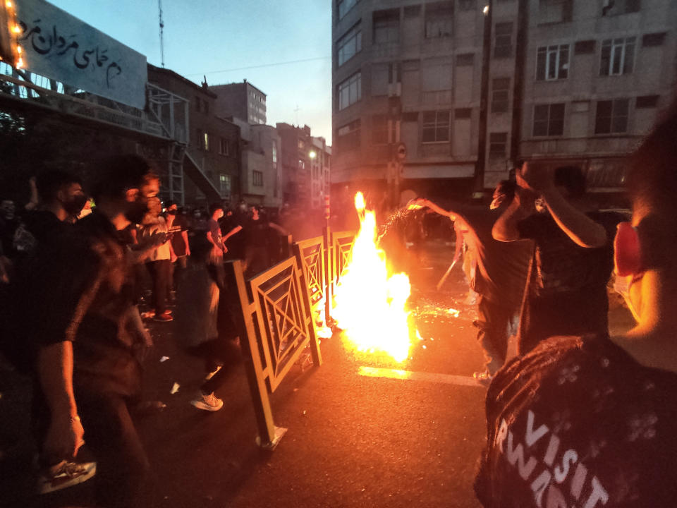 Protesters start a fire in the street. 