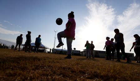 Immigrants play soccer at the U.S. government's newest holding center for migrant children in Carrizo Springs