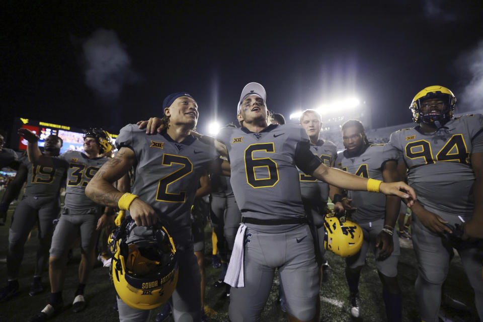 West Virginia's Rodney Gallagher III (2) and Garrett Greene (6) celebrate during the end of the team's NCAA football game against Duquesne, Saturday, Sept. 9, 2023, in Morgantown, W.Va. (AP Photo/Chris Jackson)