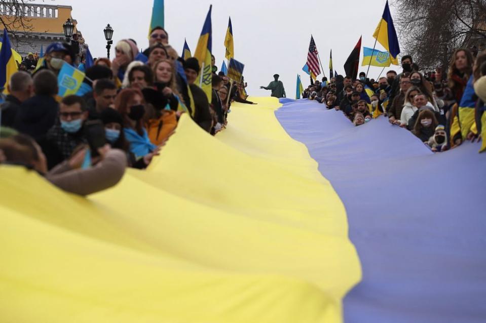 Protestors hold up a long Ukrainian flag to show their support for Ukraine's integrity in the southern port city of Odesa on Feb. 21, 2022. (Oleksandr Gimanov/AFP via Getty Images)