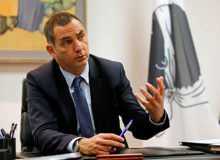 Gilles Simeoni, leader of Corsica's regional council speaks beside the Corsican flag during an interview with Reuters in Ajaccio, on the French Mediterranean island of Corsica, January 30, 2018. Picture taken January 30, 2018. REUTERS/Jean-Paul Pelissier