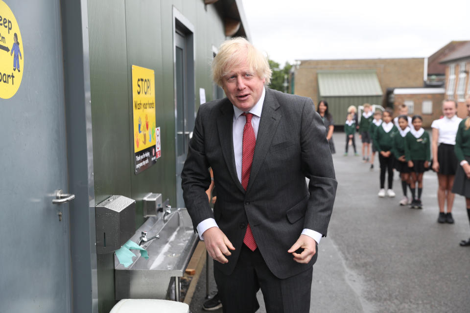 Prime Minister Boris Johnson uses a sink in the playground to wash his hands during a visit to Bovingdon Primary School in Bovingdon, Hemel Hempstead, Hertfordshire, following the announcement of a GBP 1 billion plan to help pupils catch up with their education before September after spending months out of school during the coronavirus lockdown.