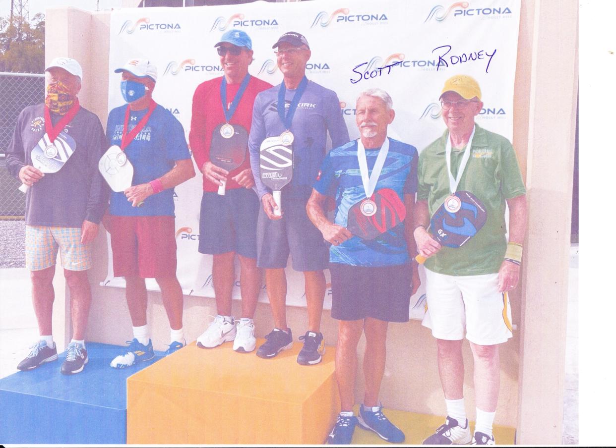 Pickleball Rocks CEO Rodney "Rocket" Grubbs, right, stands next to friend and investor Scott Siewert on the podium after medaling in a doubles match.