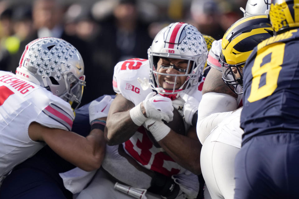 Ohio State running back TreVeyon Henderson is stopped during the first half of an NCAA college football game against Michigan, Saturday, Nov. 25, 2023, in Ann Arbor, Mich. (AP Photo/Carlos Osorio)