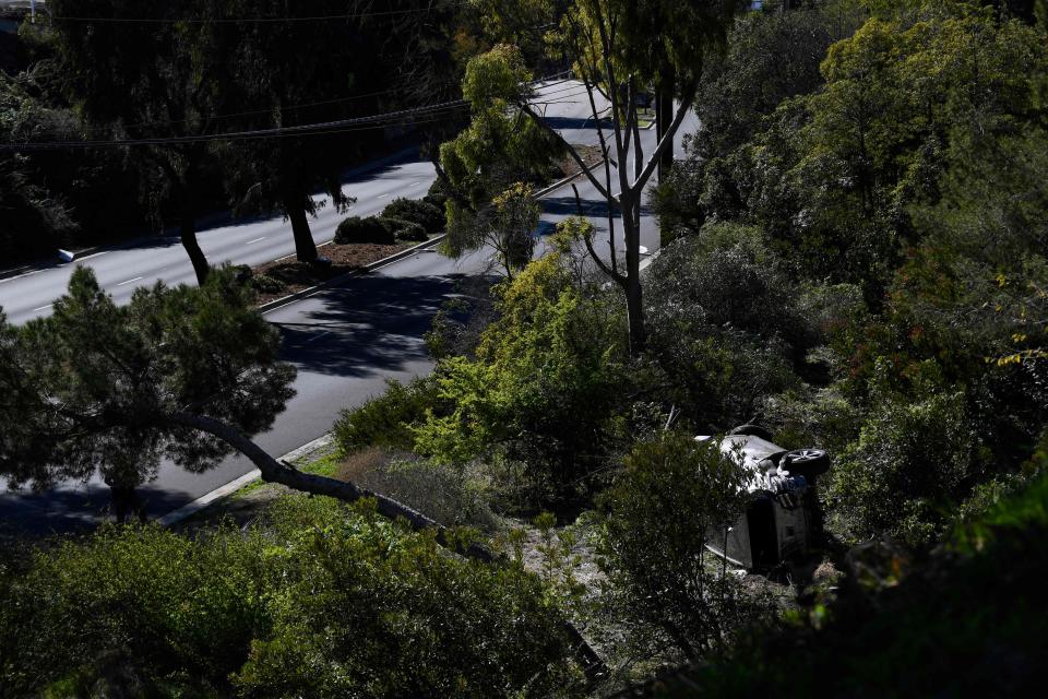 The vehicle, bottom right, drive by golfer Tiger Woods lies on its side after Tuesday's accident.